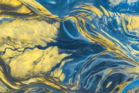 A mesmerizing blend of blue and yellow hues creates dynamic, fluid patterns, resembling natural