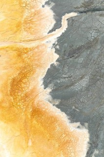A stunning aerial view of multicolor mud reveals intricate cracks and patterns Earthy tones of gray