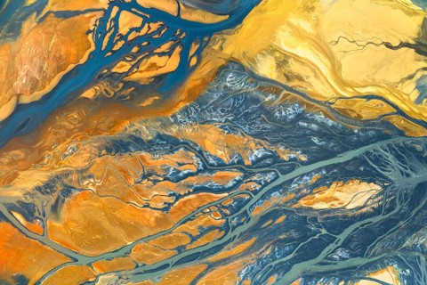 A vibrant abstract composition blending warm and cool tones in organic, flowing textures The