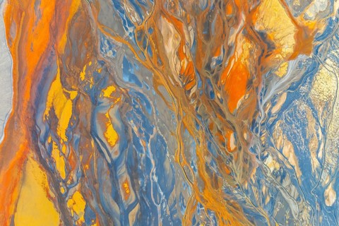 A vibrant abstract image showcasing dynamic swirling patterns in blue, orange, and yellow hues The