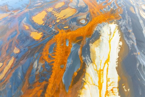 An intricate display of vibrant, swirling abstract textures featuring a dynamic blend of orange,