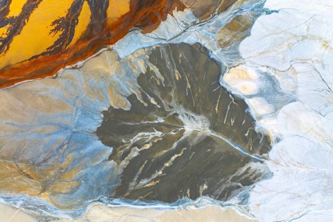 A stunning aerial view showcasing fluid multicolored abstract textures, resembling vibrant
