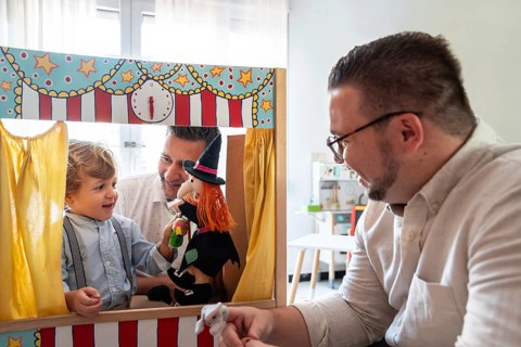 A joyful moment with a gay couple and their son engaging in playful activities. The scene reflects