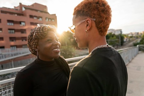 A loving LGBT multiethnic couple shares a tender moment while basking in the warm glow of the