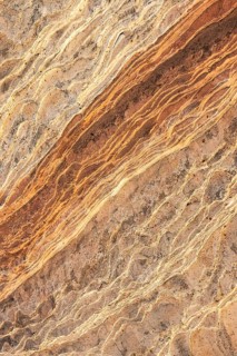 An intricate, natural lines and patterns of golden desert sandstone, emphasizing its rich, warm