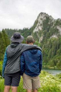 Two people embrace while admiring the picturesque mountain landscape of Lac de Taney, Switzerland