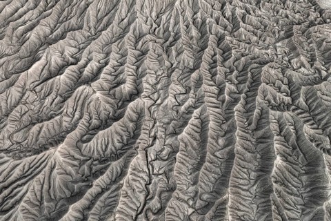 Stunning aerial photograph capturing the intricate, wavy patterns of the eroded land formations at