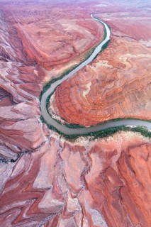 An aerial shot captures the serpentine path of Rio San Juan as it carves through the striking red
