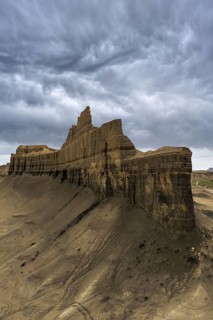 Moody clouds loom over the rugged Caineville Mesa in Utah, USA, highlighting the dramatic landscape