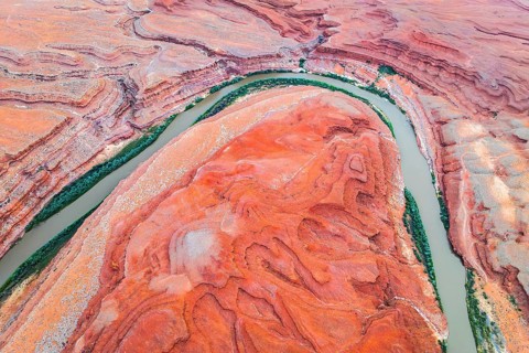 Stunning aerial shot capturing the sinuous Rio San Juan winding through the dramatic red rock