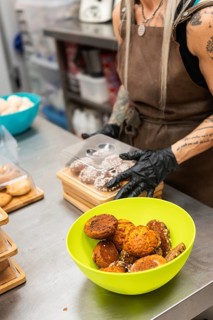 A baker at an Italian bakery prepares fresh pastries on a stainless steel countertop A vibrant