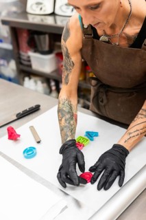 A skilled artisan in an Italian bakery decorates fondant Wearing gloves and an apron, they craft
