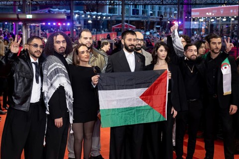 Actors and crew of the film Chronicles From the Siege hold a flag of Palestine on the Red Carpet