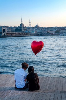 Istanbul, Turkey. 20th October 2019 A romantic couple sit beside the Golden Horn with a red heart