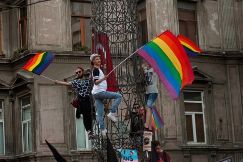 Istanbul, Turkey. August 21st, 2016 Rainbow flag waiving protestors climb a statue near Istiklal