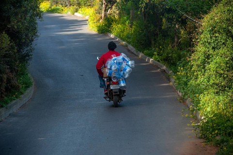 Istanbul, Turkey. 18th April 2016 A man riding a motorcycle with empty plastic water bottles on the