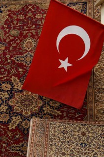 Istanbul, Turkey, February 23rd 2018. A Turkish flag and antique carpet for sale in a shop in the