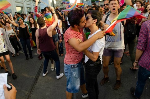 Istanbul, Turkey. 28th June, 2015 Two Gay Turkish men kiss among people celebrating Gay Pride in