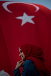 Istanbul, Turkey, July 17th 2016 Turkish Muslim Woman with red headscarf with Turkish flag behind