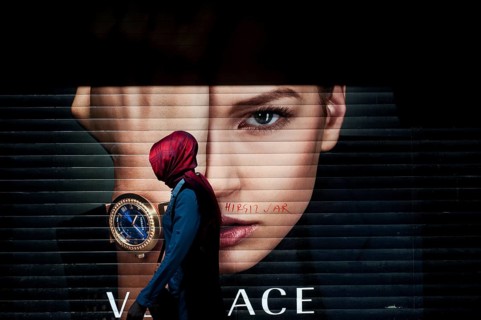 Istanbul, Turkey. April 28th 2016 A Turkish Muslim woman wearing a red Hijab walking past an