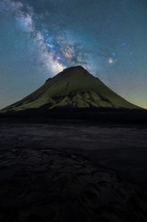 A striking view of an Icelandic mountain silhouetted against the vibrant Milky Way The serene night