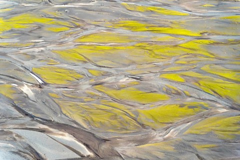 Aerial view showcasing intricate textures and patterns created by vibrant Icelandic rivers. Natural