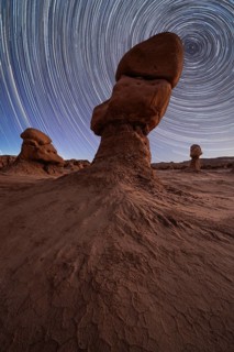Captivating night sky with star trails above unique sandstone formations in Goblin Valley State