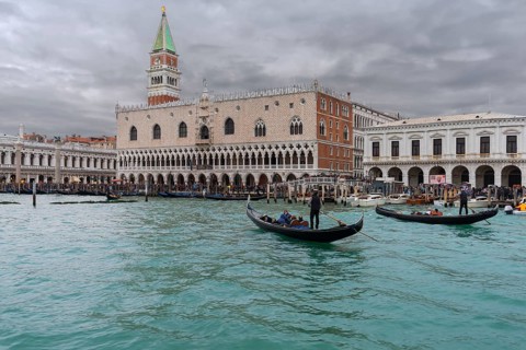 St. Mark's Square with Campanile and the Ducal Palace, in front gondola with tourists on the Grand