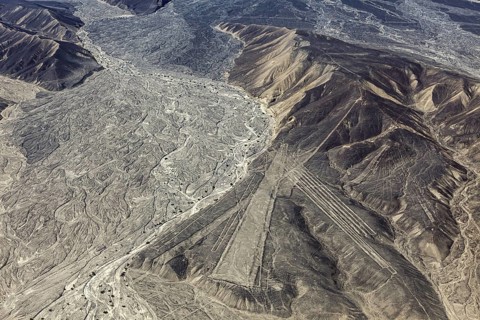 Brown desert landscape with distinctive line patterns and geoglyphs, the geoglyphs and drawings in