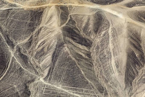 Aerial view of geoglyphs in the rugged Nazca desert with distinctive lines, the geoglyphs and