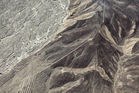 Aerial view of a desert with distinctive hills and line patterns, the geoglyphs and images in the