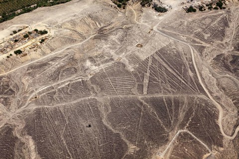 Nazca lines spread across the desert landscape in detailed patterns, the geoglyphs and drawings in