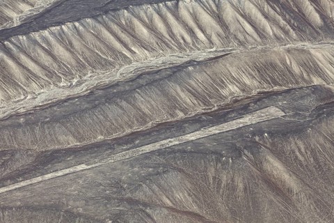 Aerial view of the drawn Nazca lines that cover sandy hills, the geoglyphs and drawings in the