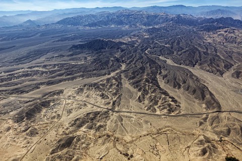 Wide and dry desert landscape with flat mountains and secluded roads, the geoglyphs and images in