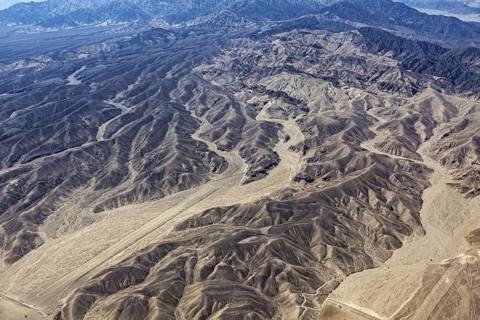 Ruffled mountain landscape in the desert with geoglyphs and sandy tones, The geoglyphs and