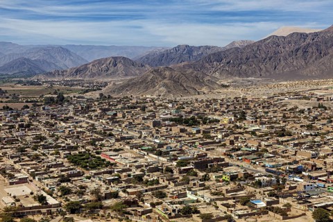 A panoramic view of a city against a backdrop of mountains and clear skies, the city of Nasca in