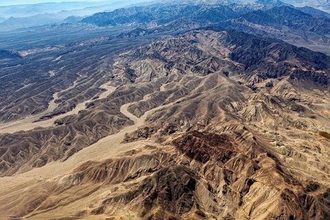 Extensive desert landscape with mountain ranges and sandy valleys from the air, The desert