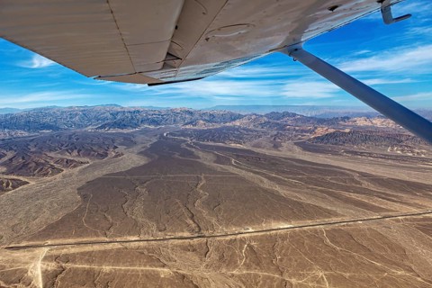 Desert landscape with a view from an airplane, mountains and a clear blue sky, The desert landscape