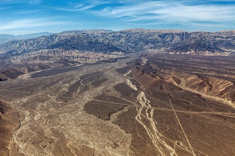 Barren desert plain with extensive mountains seen from a bird's eye view, the desert landscape near