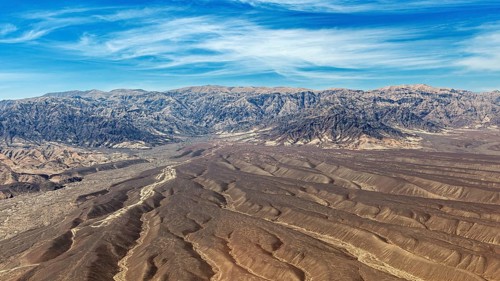 Landscape with dry desert area and mountain chain under blue sky, The desert landscape near Nasca