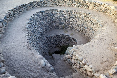 Deep spiral of stones winding into the ground, The ancient Nazca wells (puquios) near Nazca, Peru