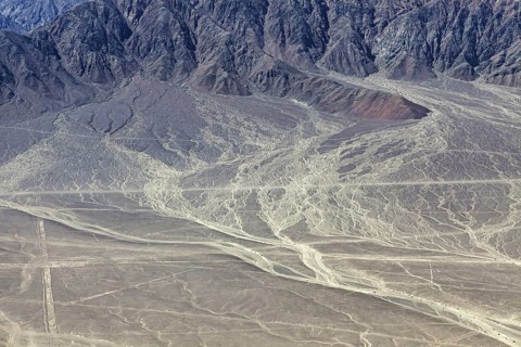 Erosion-prone desert landscape with rough mountain structures in the background, The desert
