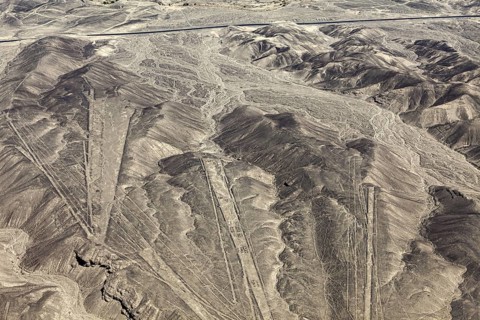 Extensive view of a desert region with geometric patterns in the mountains, the geoglyphs and