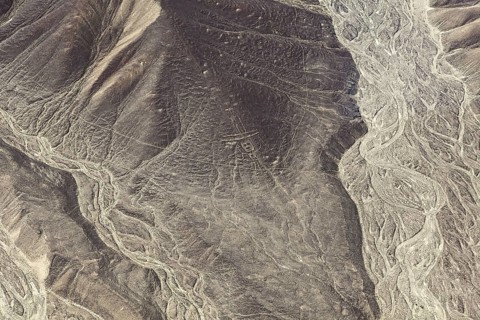 Patterns and lines span a rugged mountain landscape, the geoglyphs and drawings in the desert near