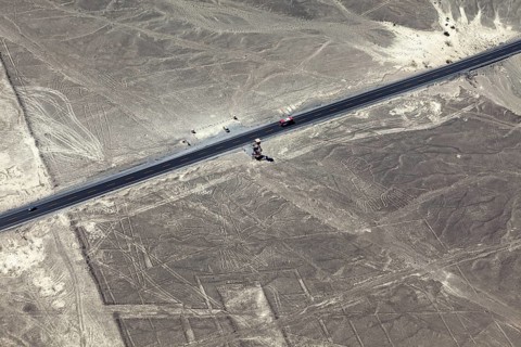 View of a road leading through a desert landscape with geoglyphs, the geoglyphs and paintings in