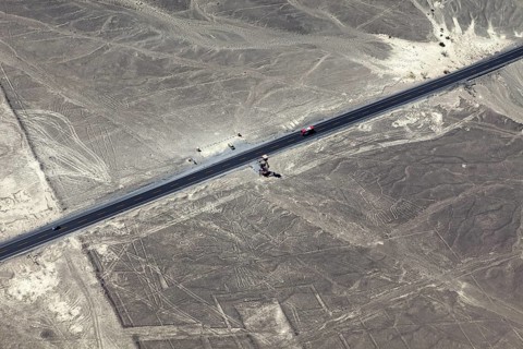 Aerial view of a dry environment with Nazca lines and a parallel road, The geoglyphs and images in