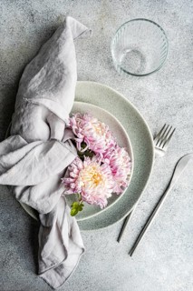 A serene table setting featuring delicate chrysanthemum flowers resting on stacked plates,