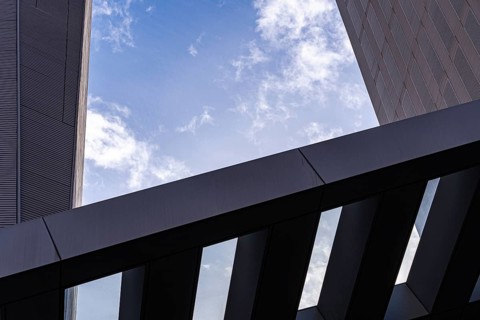 A detailed close-up of modern architecture featuring sharp lines and geometric forms against a