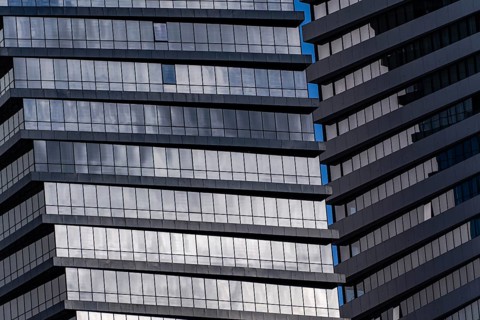 A detailed look at a modern skyscraper featuring geometric patterns formed by windows and