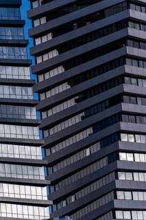 A detailed view of modern skyscraper exteriors featuring blue-tinted glass and staggered metal